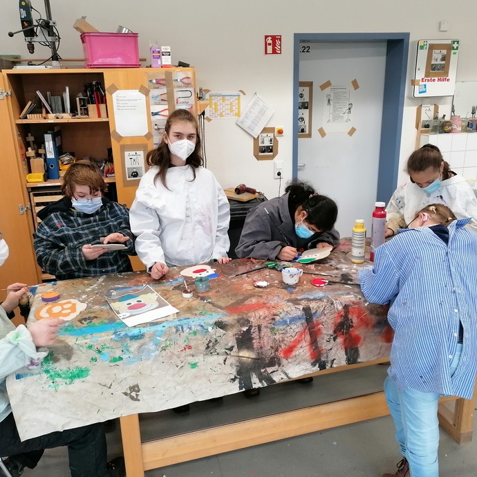 Schüler:innen in Werkraum am Werktisch (vergrößerte Bildansicht wird geöffnet)