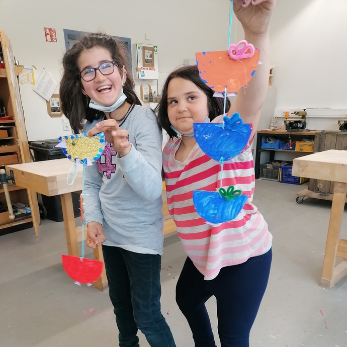 Zwei Schülerinnen mit ihren Werkstücken (vergrößerte Bildansicht wird geöffnet)